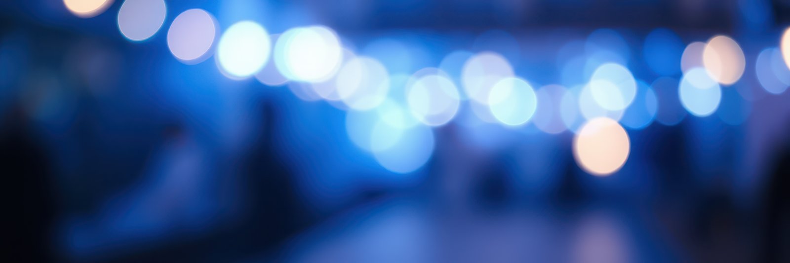 Soft blue lights create a dreamy atmosphere at an evening gathering in a casual setting